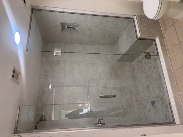 Custom glass shower door with brushed nickel hardware