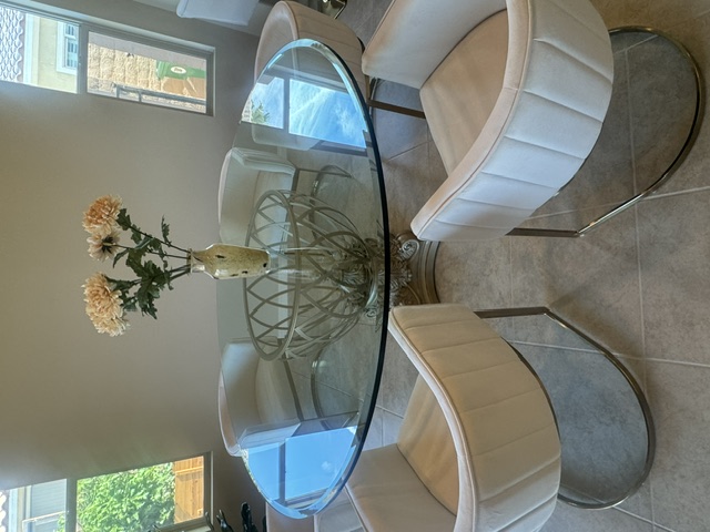 Round glass dining table top with white chairs