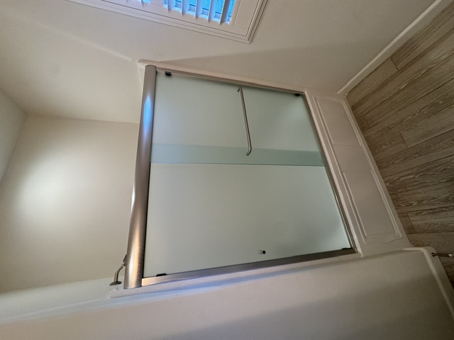 Open walk-in shower with glass panel