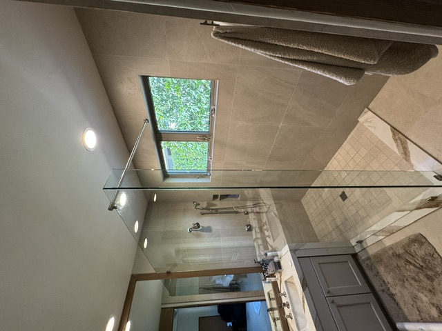 Shower door installation with chrome fixtures