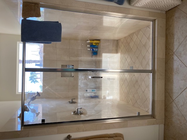 Classic frameless shower door with tan tile