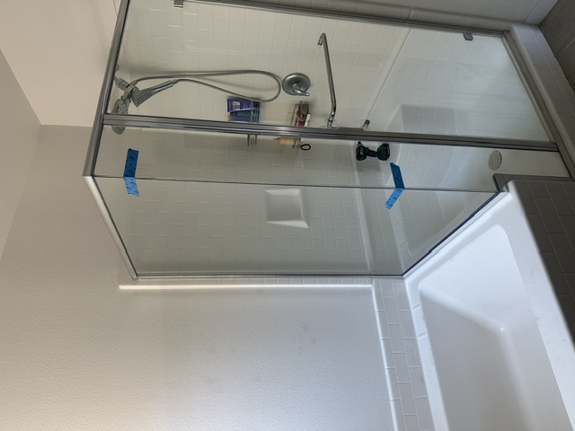 Frameless glass shower door with chrome hardware