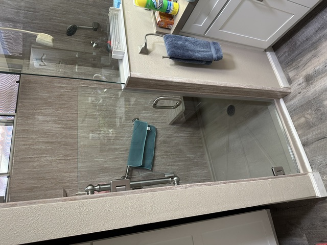 Gray tile shower with frameless glass door
